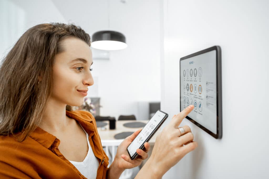 Young woman controlling home with a digital touch screen